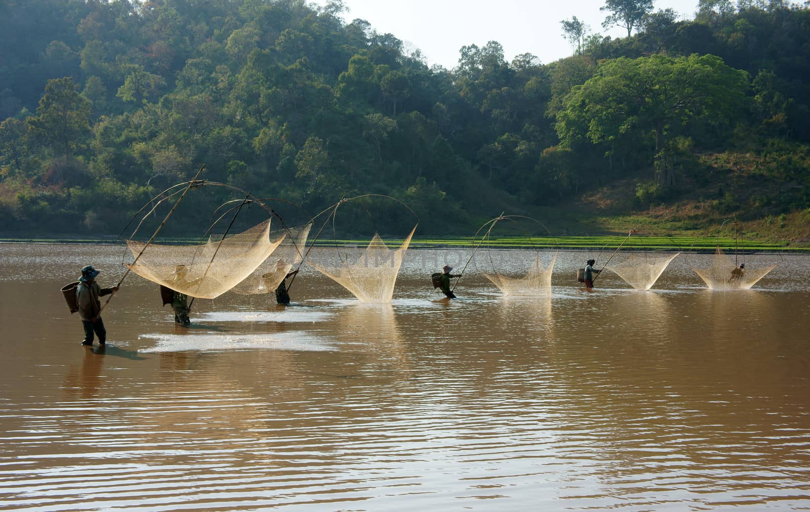 BUON ME THUOT, VIETNAM- FEB 7: People catch fish on ditch, fisherman lifting net from water, lift net is primitive traditional tool, include net, rod, four corner hang up 4 frame, Vietnam, Feb 7, 2014