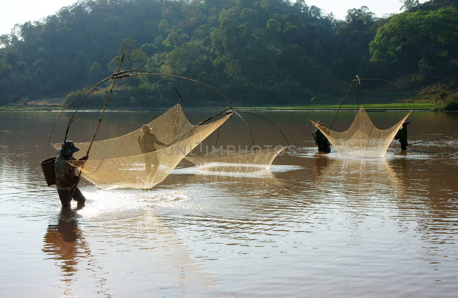 BUON ME THUOT, VIETNAM- FEB 7: People catch fish on ditch, fisherman lifting net from water, lift net is primitive traditional tool, include net, rod, four corner hang up 4 frame, Vietnam, Feb 7, 2014