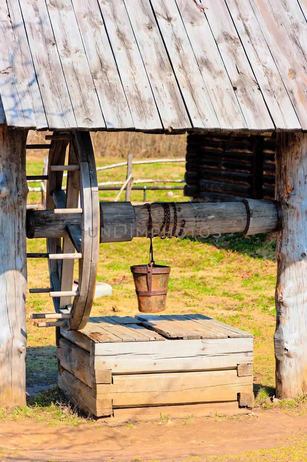 outdated wooden well with large wheel by kosmsos111