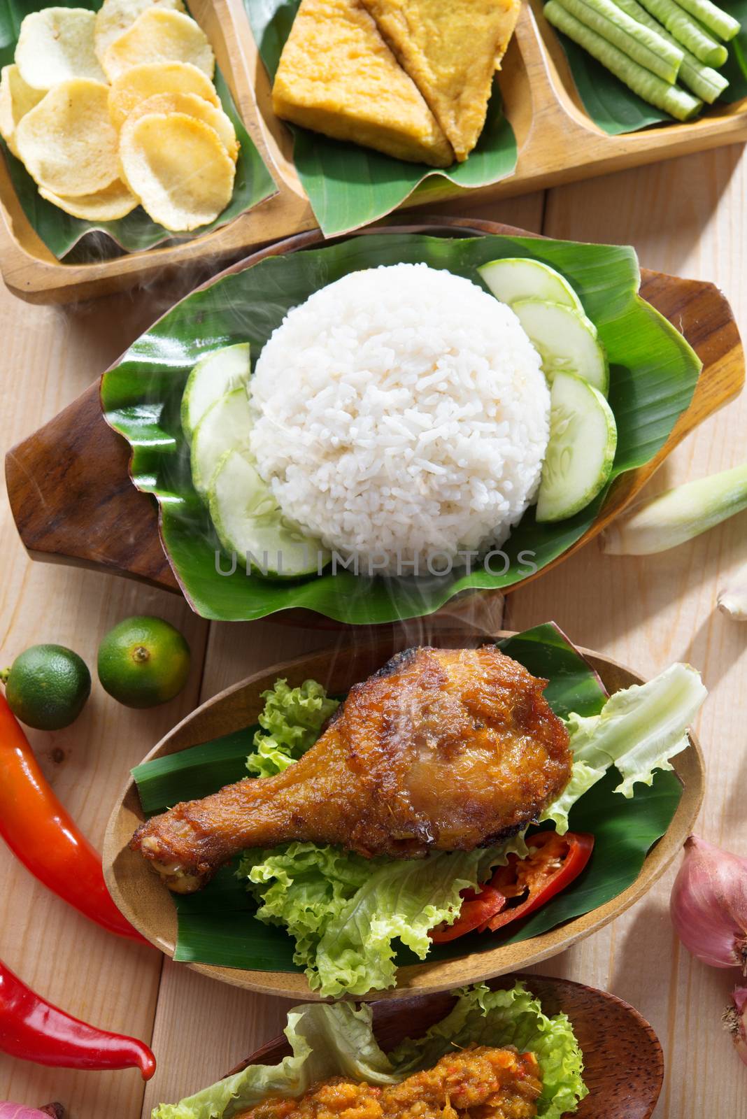 Popular Indonesian local food nasi ayam penyet, indonesian fried chicken rice. Fresh hot with steam smoke.