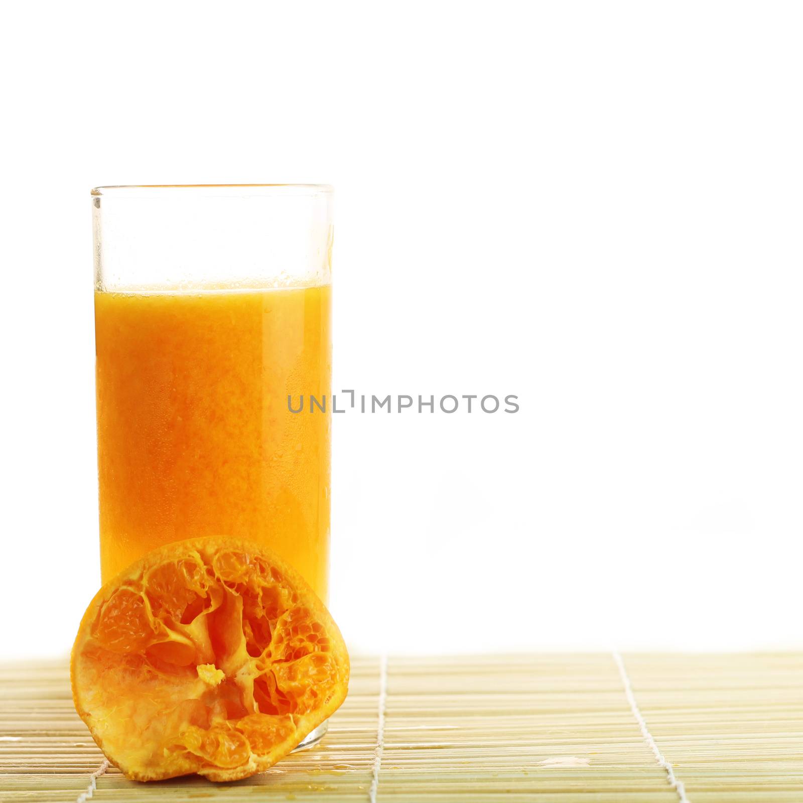 Fresh Orange juice in a glass on bamboo