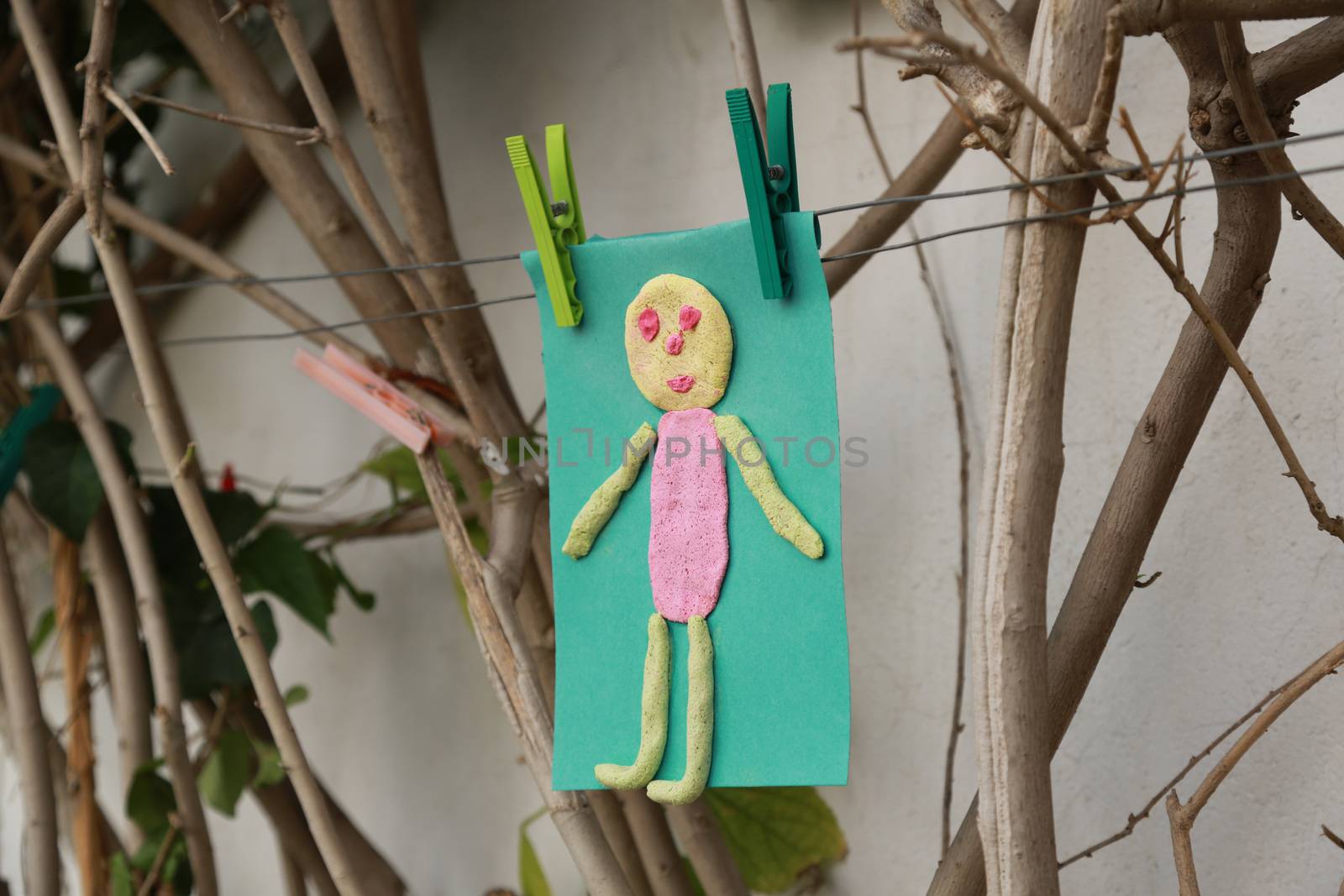 Child's handmade small man on a green color paper  by tolikoff_photography