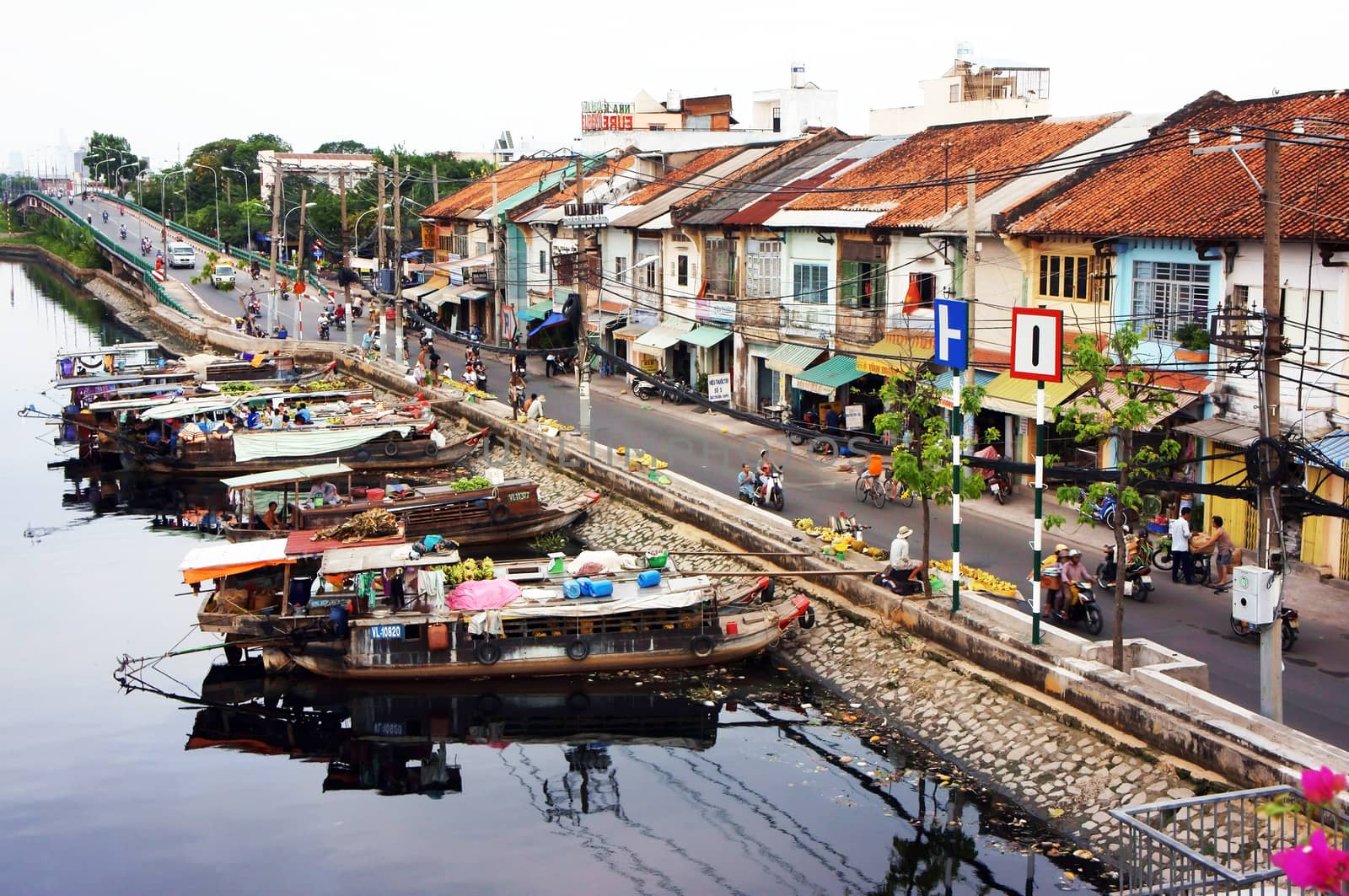 SAI GON, VIET NAM- APRIL 19:  ancient riverside city with house boat on water, motorcycle moving on road, life is crowded in Ben Binh Dong, Sai gon, Viet Nam on April 19, 2013