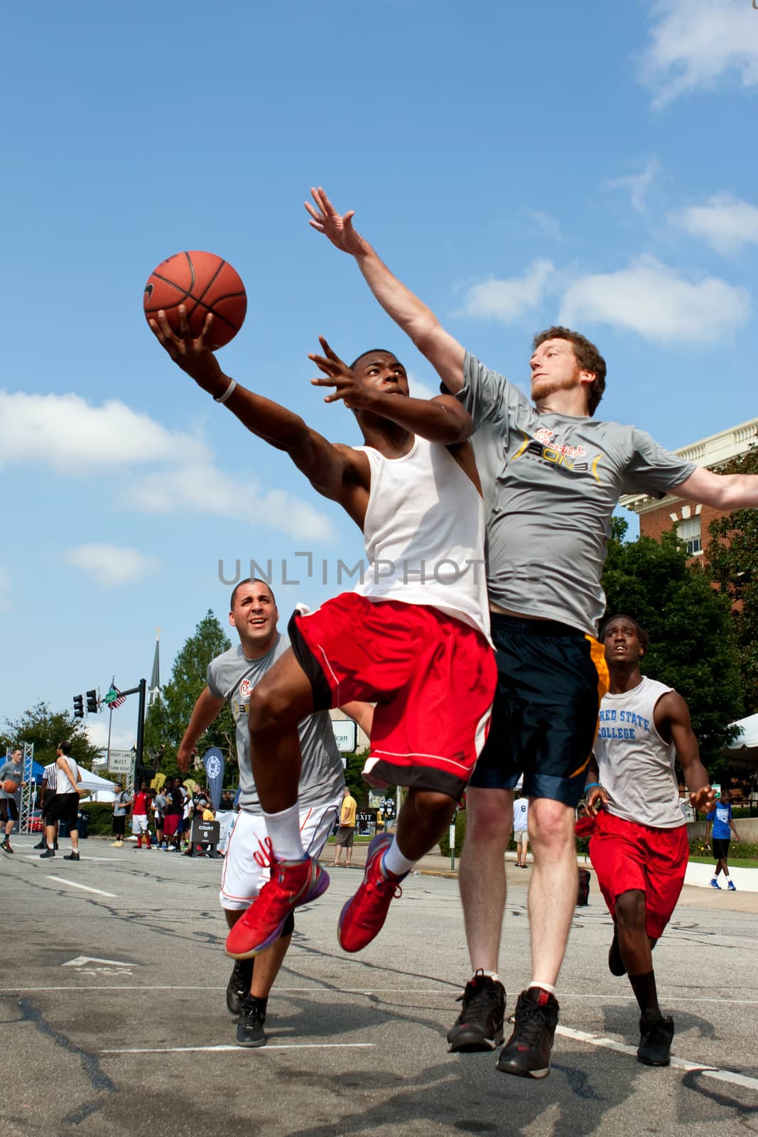 Man Shoots Against Defender In Outdoor Street Basketball Tournament by BluIz60