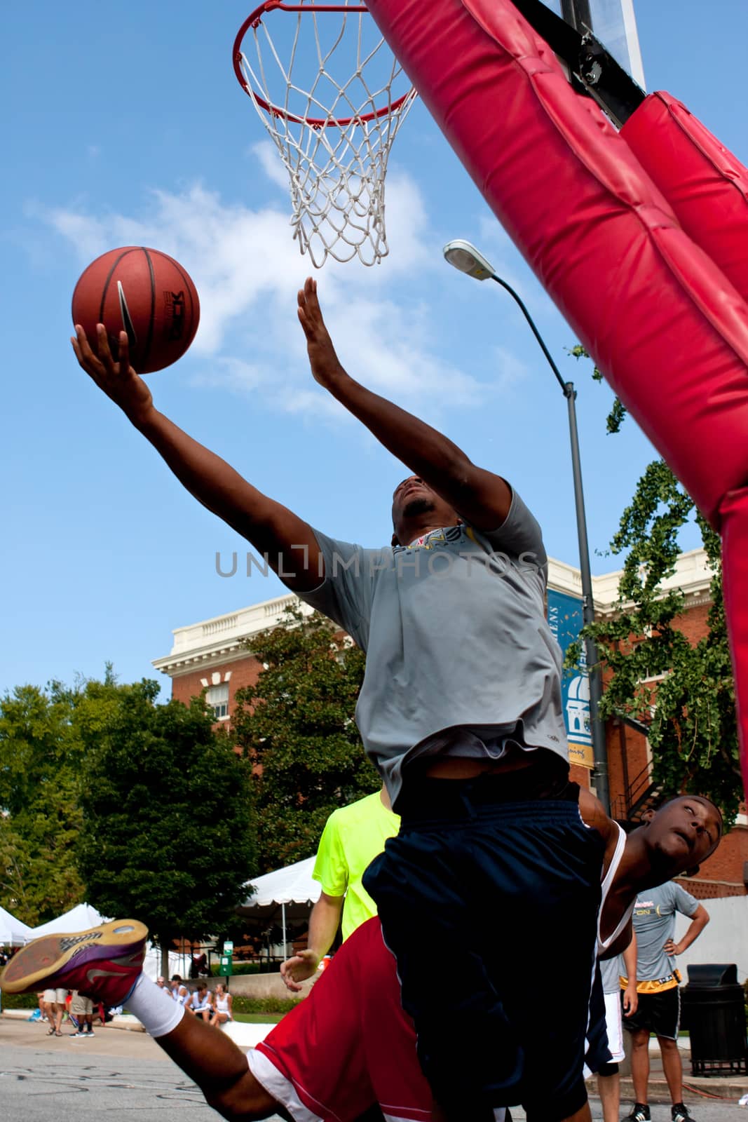 Athens, GA, USA - August 24, 2013:  A young man shoots a reverse layup in a 3-on-3 basketball tournament held on the streets of downtown Athens.