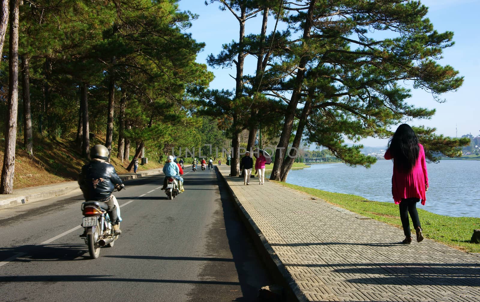 DA LAT, VIET NAM- DEC 29: Calm living in city of love, people walking on pavement along lake , this place is famous destination of traveler, Dalat, Vietnam, Dec 29, 2013                             