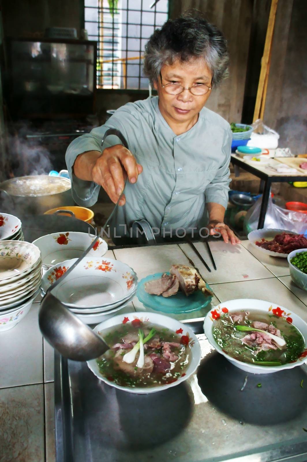 BUON ME THUOT, VIET NAM- SEPT 2: Chef prepare noodle soup to bowl: noodle, beef, sauce to serve breakfast for eater in Pho restaurant, Buonmethuot, VietNam, Sept 2, 2013