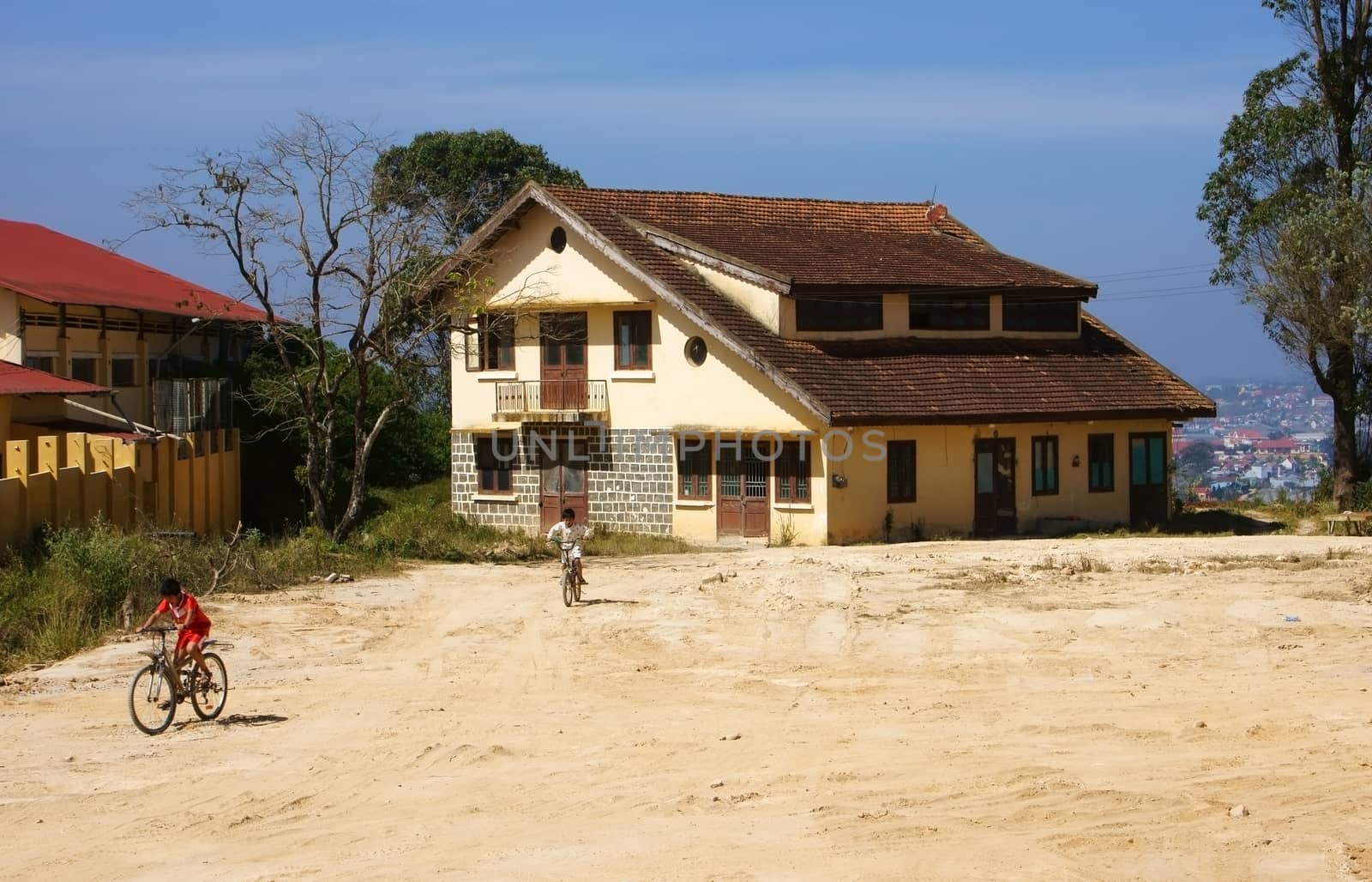 DA LAT, VIET NAM- DEC 28: Children in childhood with hobby 're riding bicycle on the court of acient house 's french time architecture in Dalat, Vietnam on Dec 28, 2013                             