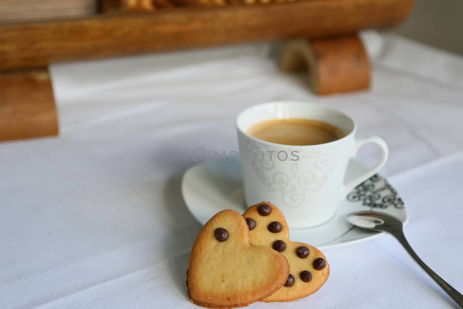 two biscuits in the form of heart and a cup of coffee