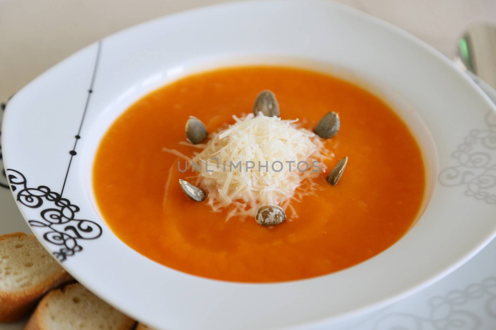 a plate of pumpkin soup with parmesan cheese