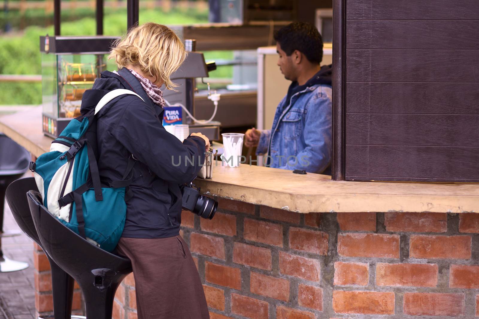 LIMA, PERU - AUGUST 16, 2011: Unidentified woman paying at a food stall on August 16, 2011 in Miraflores, Lima, Peru