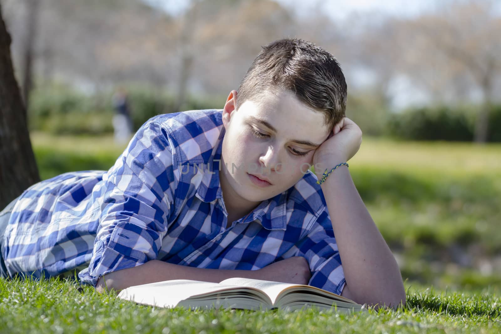 Young boy reading a book in the woods with shallow depth of fiel by FernandoCortes