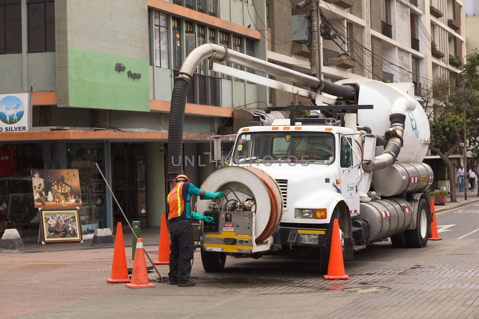 LIMA, PERU - FEBRUARY 11, 2012: Unidentified person of the Concyssa S.A. company cleaning the sewage with the help of a truck on February 11, 2012 in Miraflores, Lima, Peru