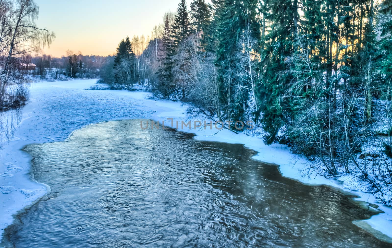 Icy winter river flowing in the evening sun