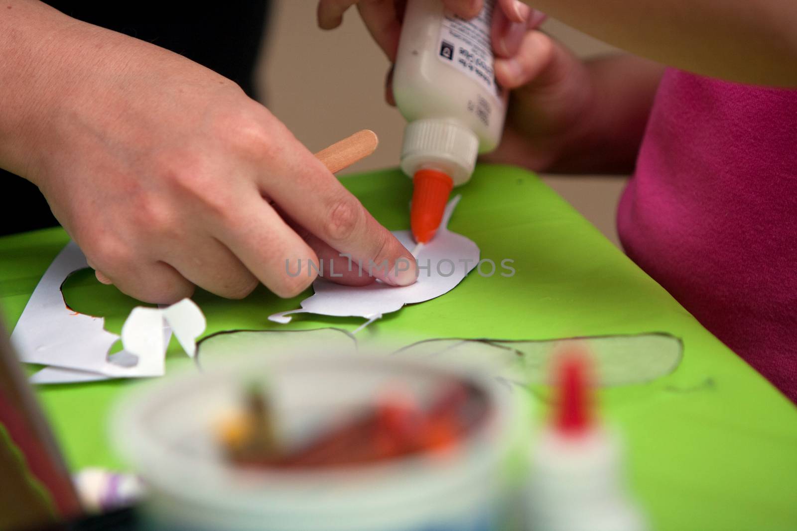 Mother's Hand Helps Child Glue Art Project At Summer Festival by BluIz60