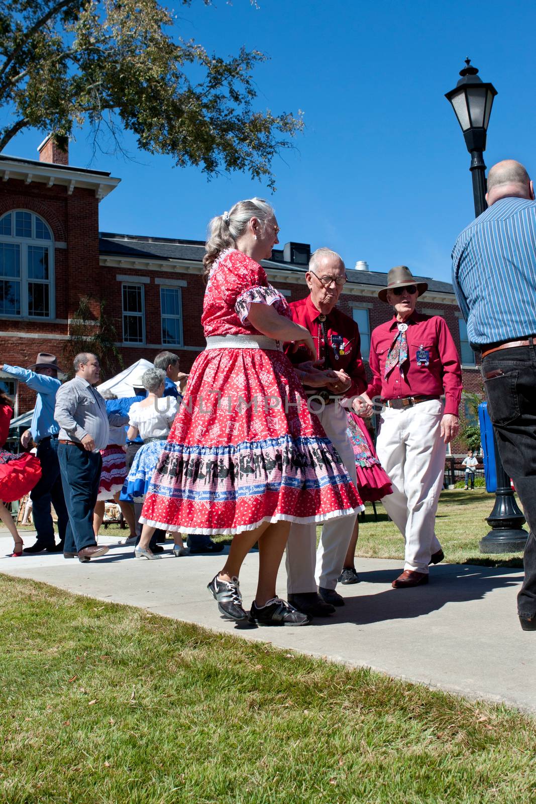Senior Citizen Couple Square Dances At Outdoor Event by BluIz60