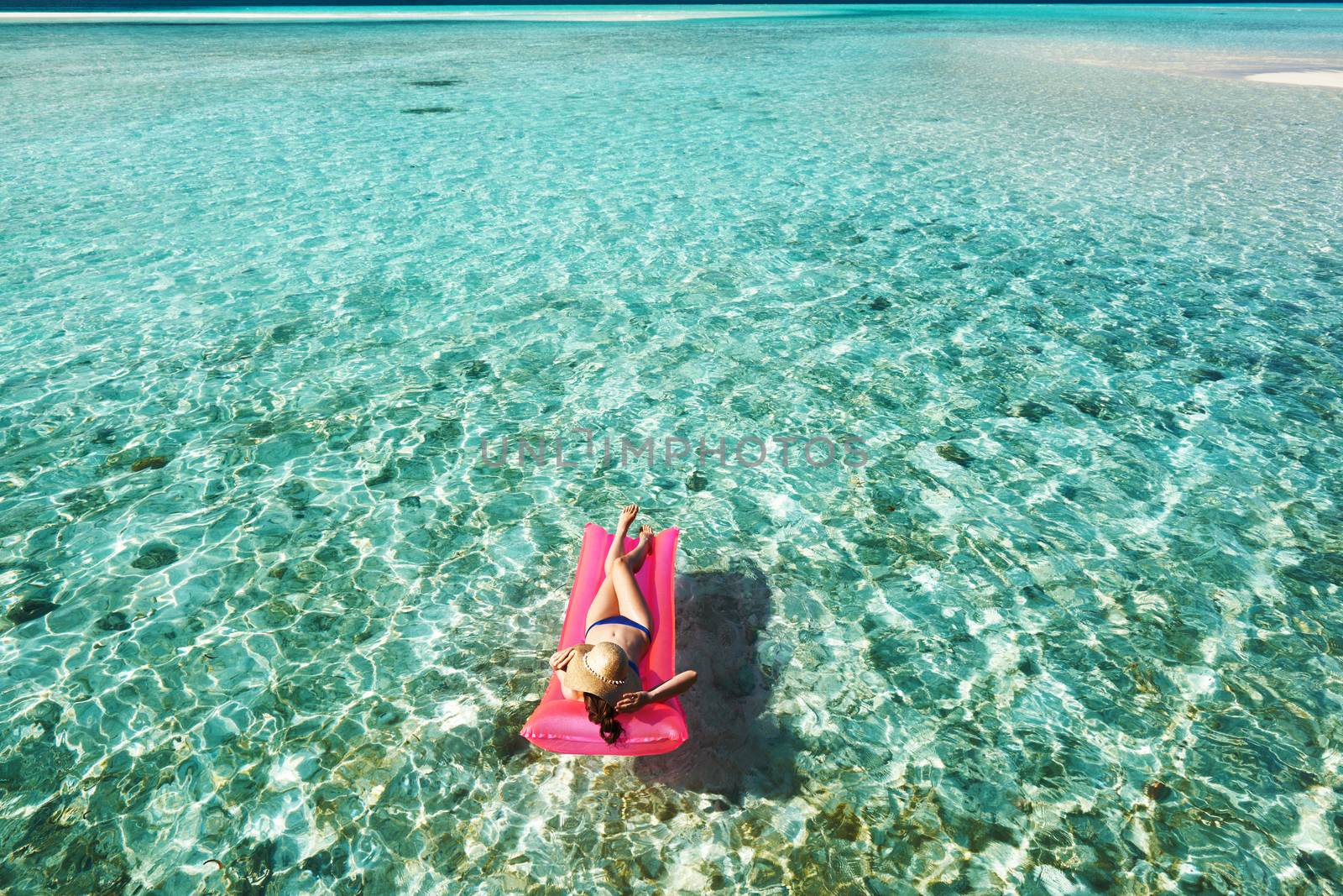 Woman relaxing on inflatable mattress at the beach