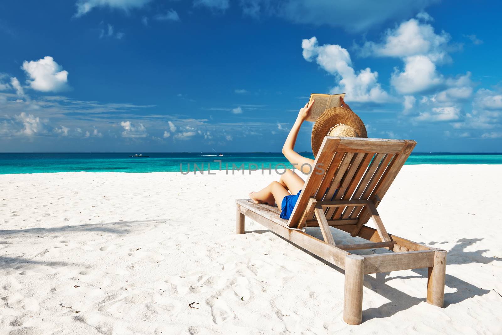 Young woman reading a book at the beach