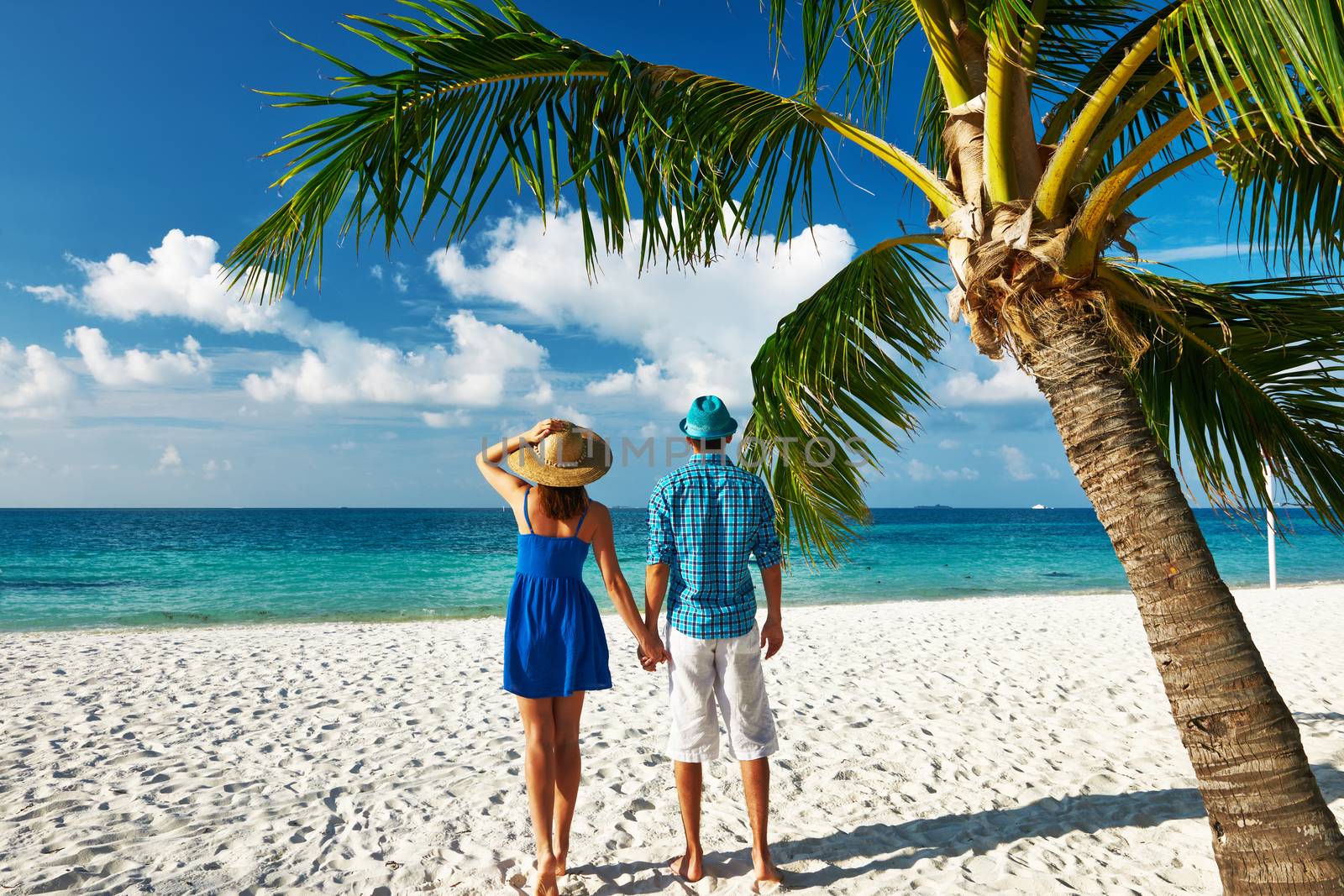 Couple in blue clothes on a tropical beach at Maldives