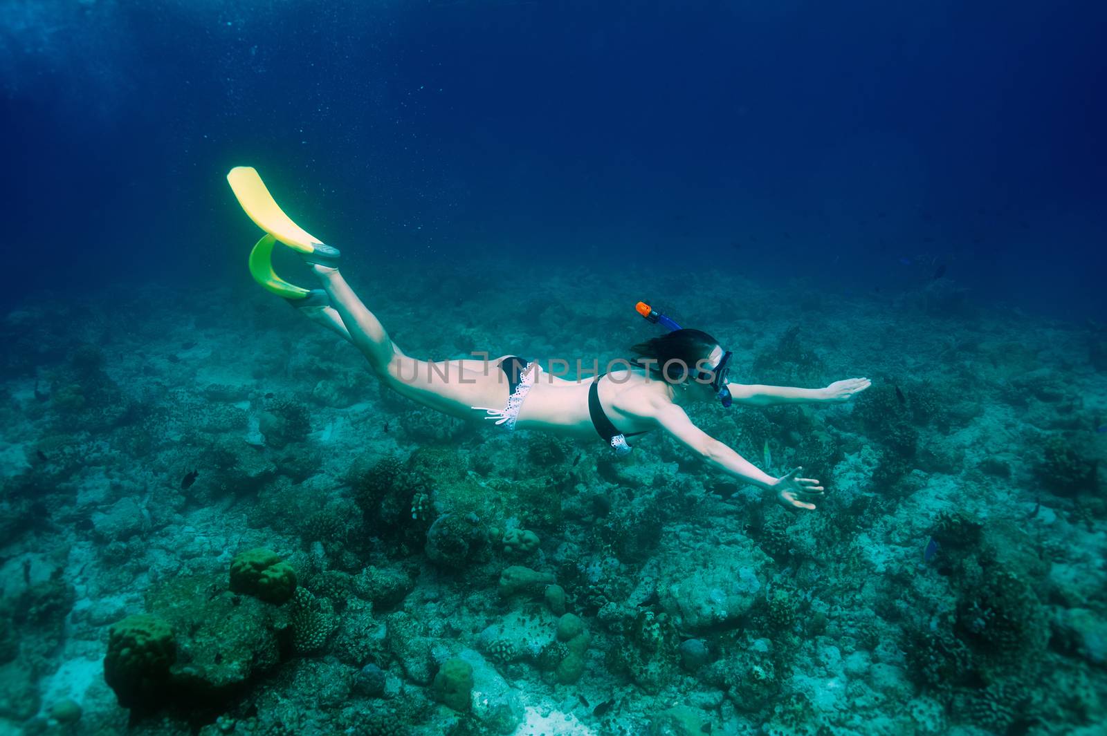 Woman with mask snorkeling in clear water 