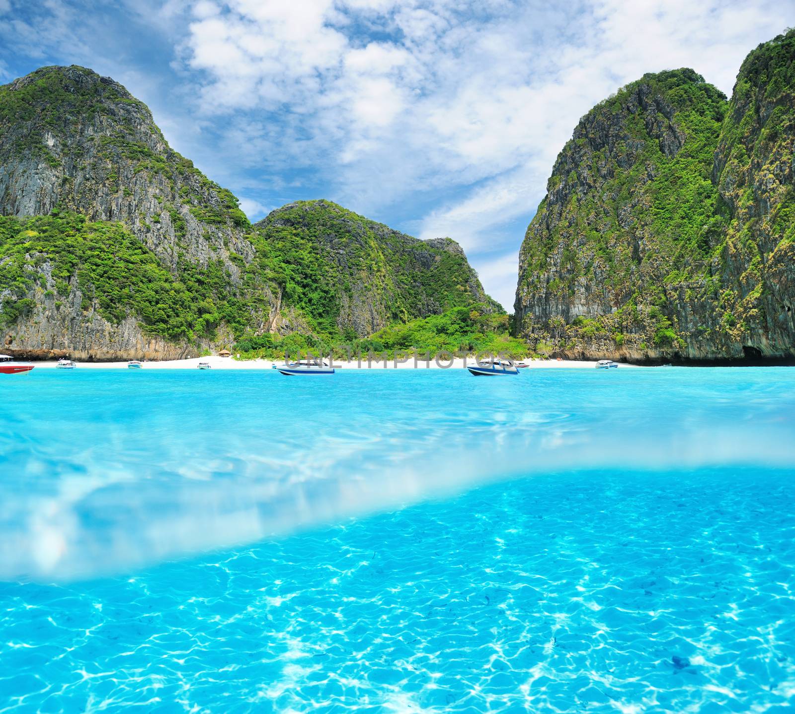 Beautiful lagoon at  Phi Phi Ley island with white sand bottom underwater and above water split view