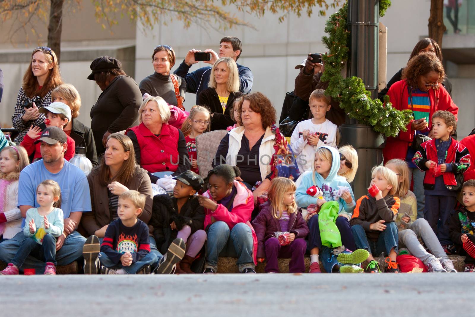 Atlanta, GA, USA - December 1, 2012:  Spectators watch from the sidewalk and street curb as the Atlanta Christmas parade takes place down Peachtree Street in downtown Atlanta.