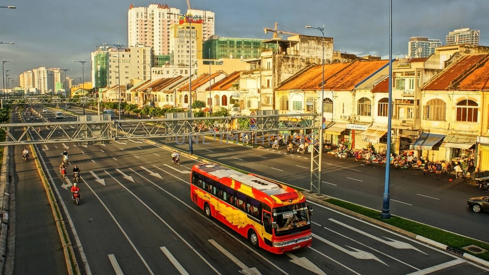 HO CHI MINH CITY, VIET NAM- NOVEMBER 22: City with row of houses in morning, vehicles moving on Dong Tay Boulevard in Ho Chi Minh, Viet Nam on November  22, 2013