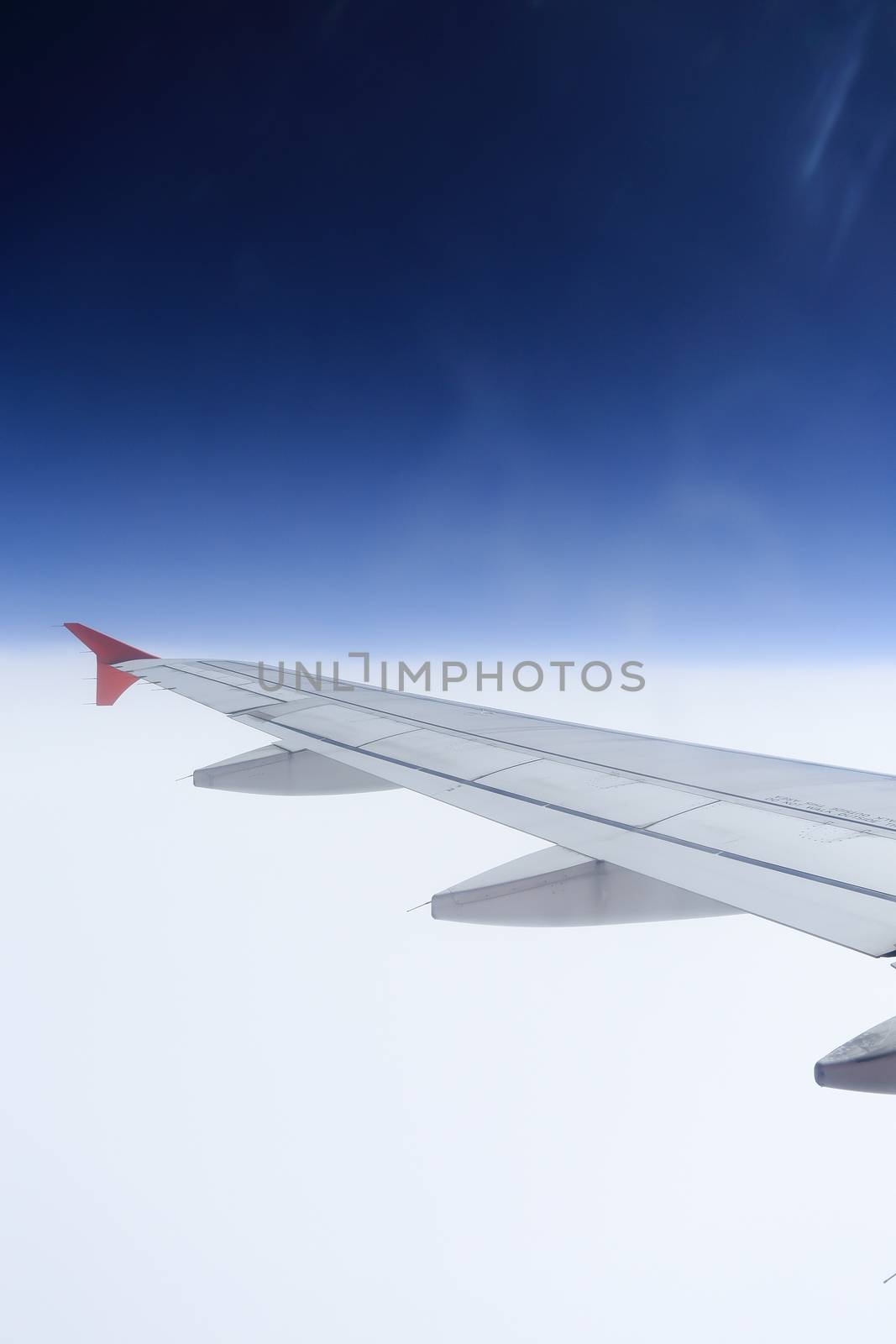 Wing of an airplane flying above the clouds. people looks at the sky