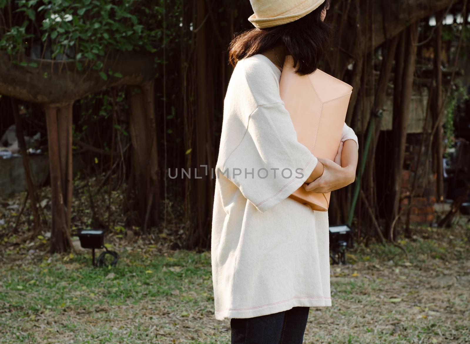 Young fashion girl with handbag on nature background