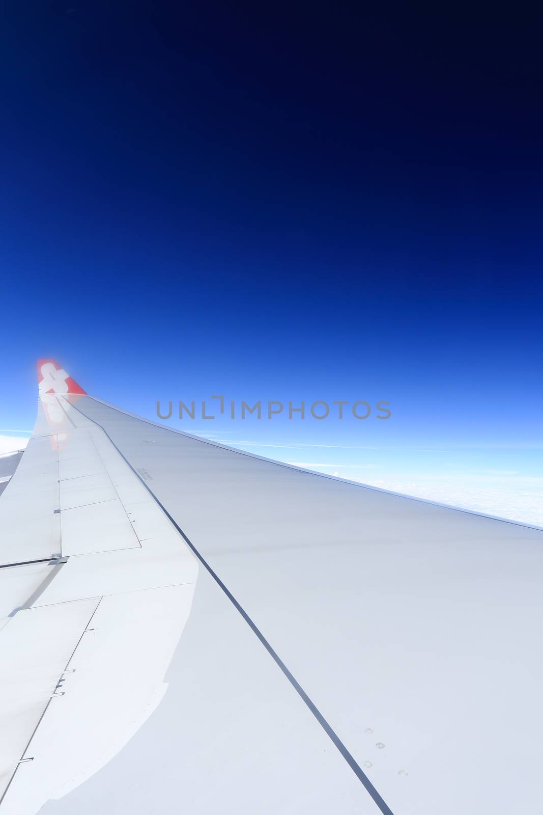 Wing of an airplane flying above the clouds. by rufous