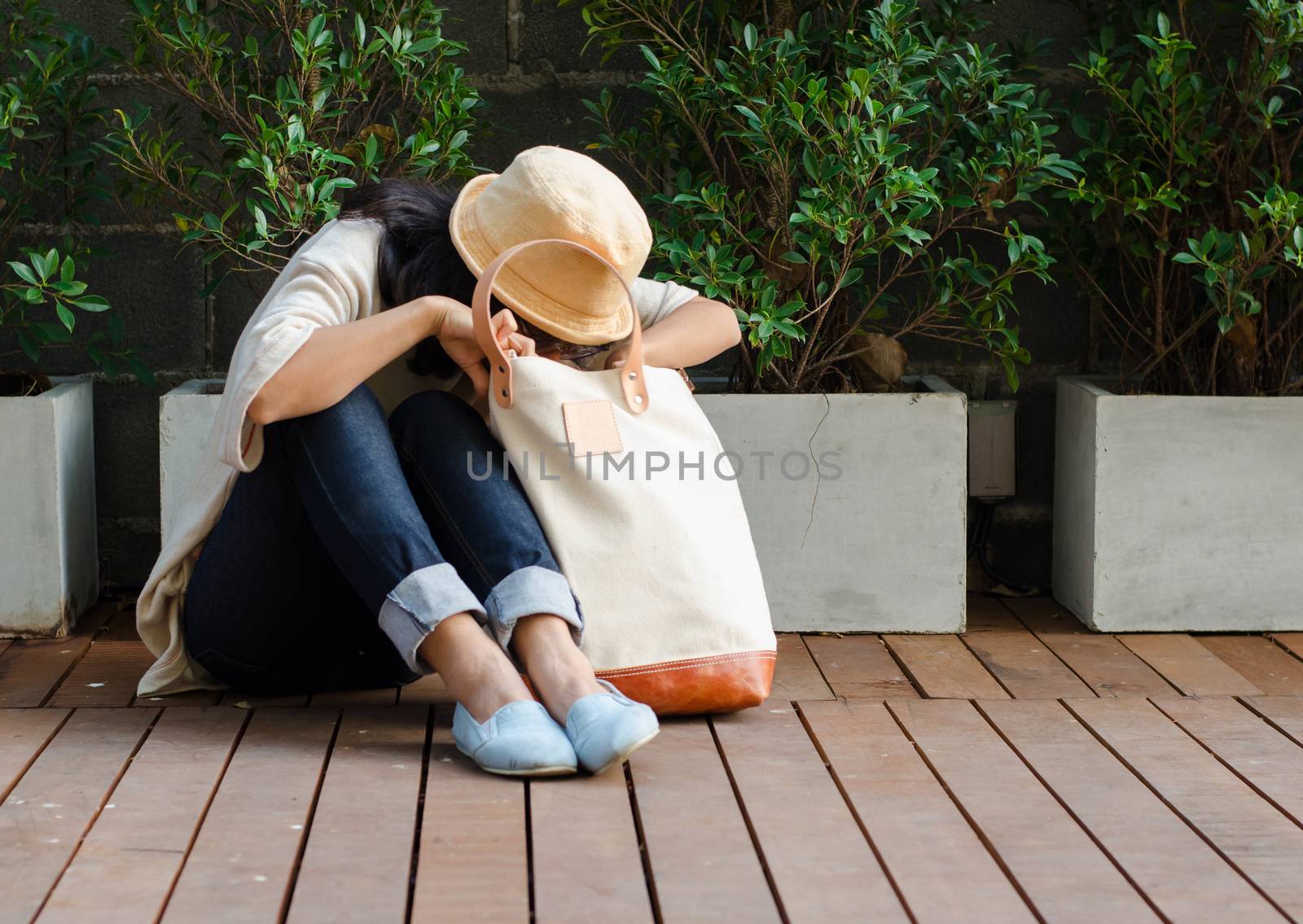 Young woman finding something in a canvas bag by siraanamwong