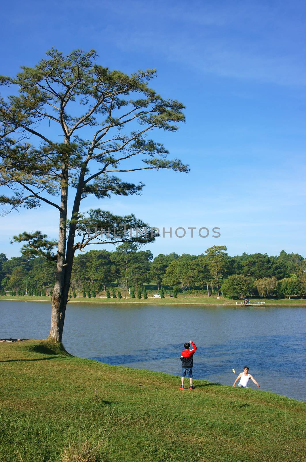 DA LAT, VIET NAM- DEC 29: Healthy lifestyle of dad (father)  and son (children), travel on vacation and do exercise together at lakeshore in Dalat, Vietnam on Dec 29, 2013