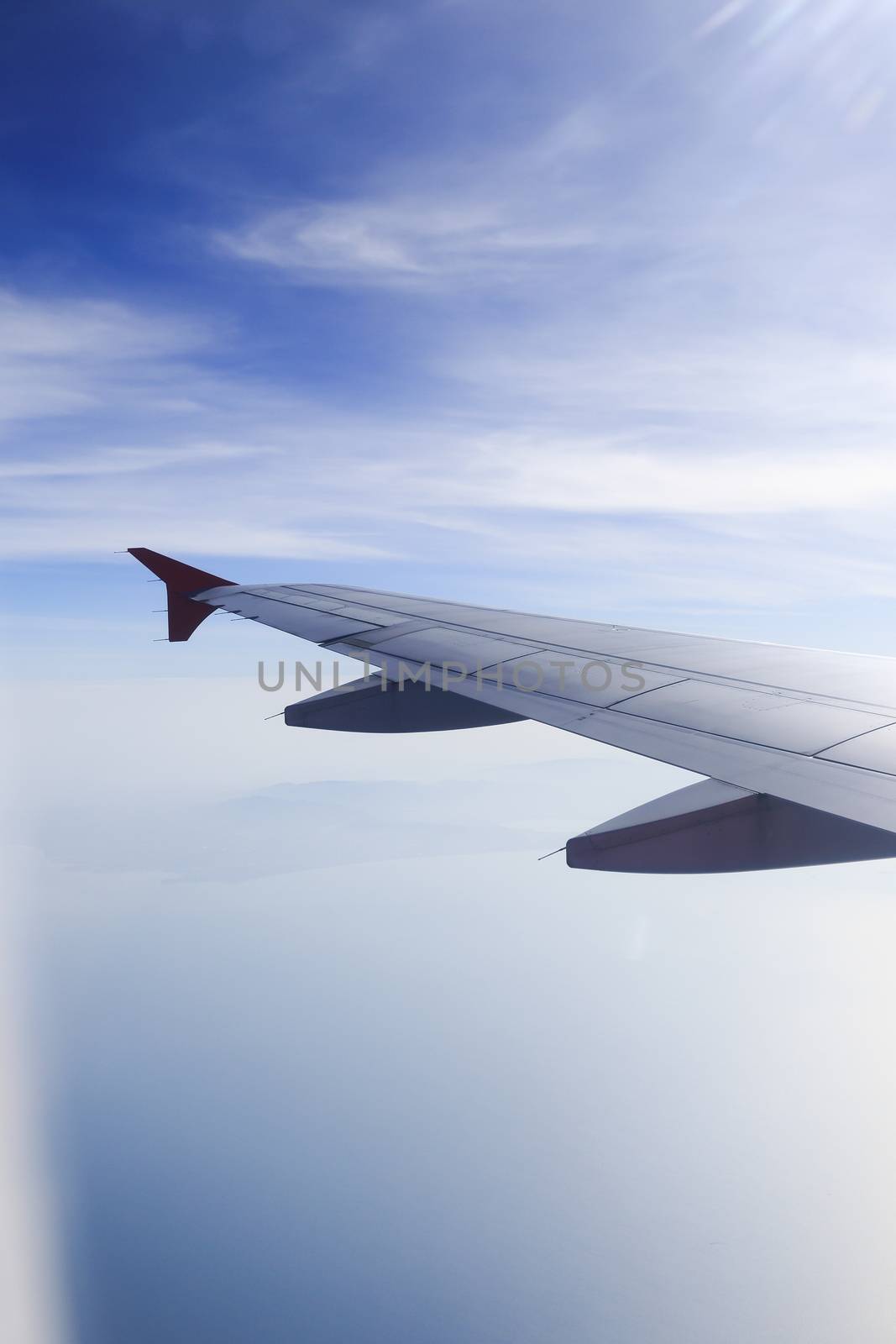 Wing of an airplane flying above the clouds. people looks at the sky