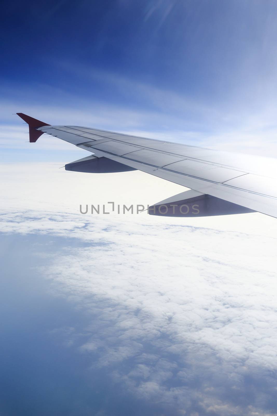 Wing of an airplane flying above the clouds. people looks at the sky