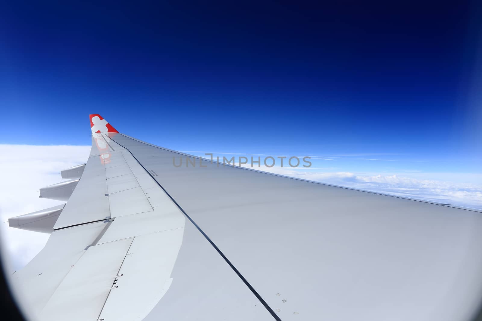 Wing of an airplane flying above the clouds. people looks at the sky