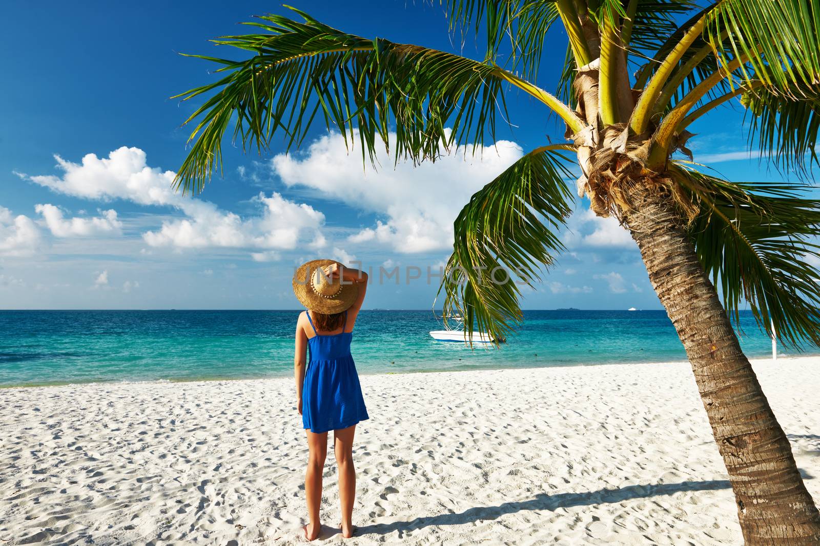 Woman in blue dress on a tropical beach at Maldives