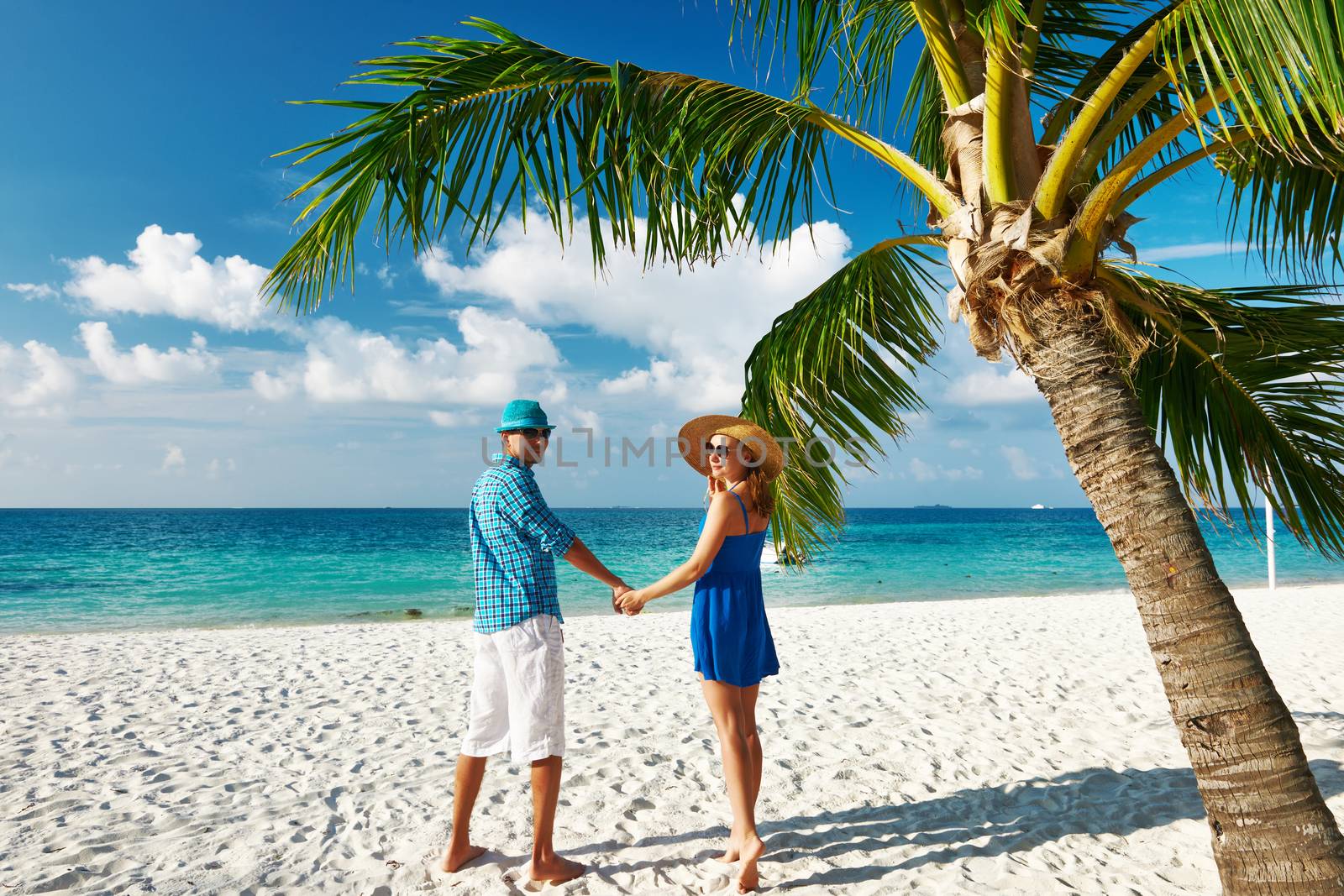 Couple in blue clothes on a tropical beach at Maldives