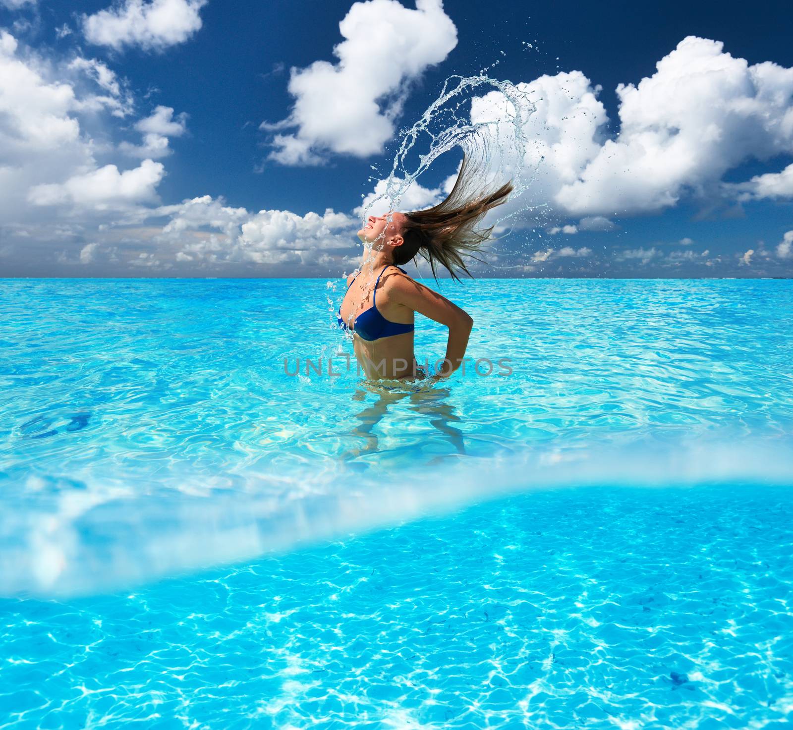 Woman splashing water with her hair in the ocean