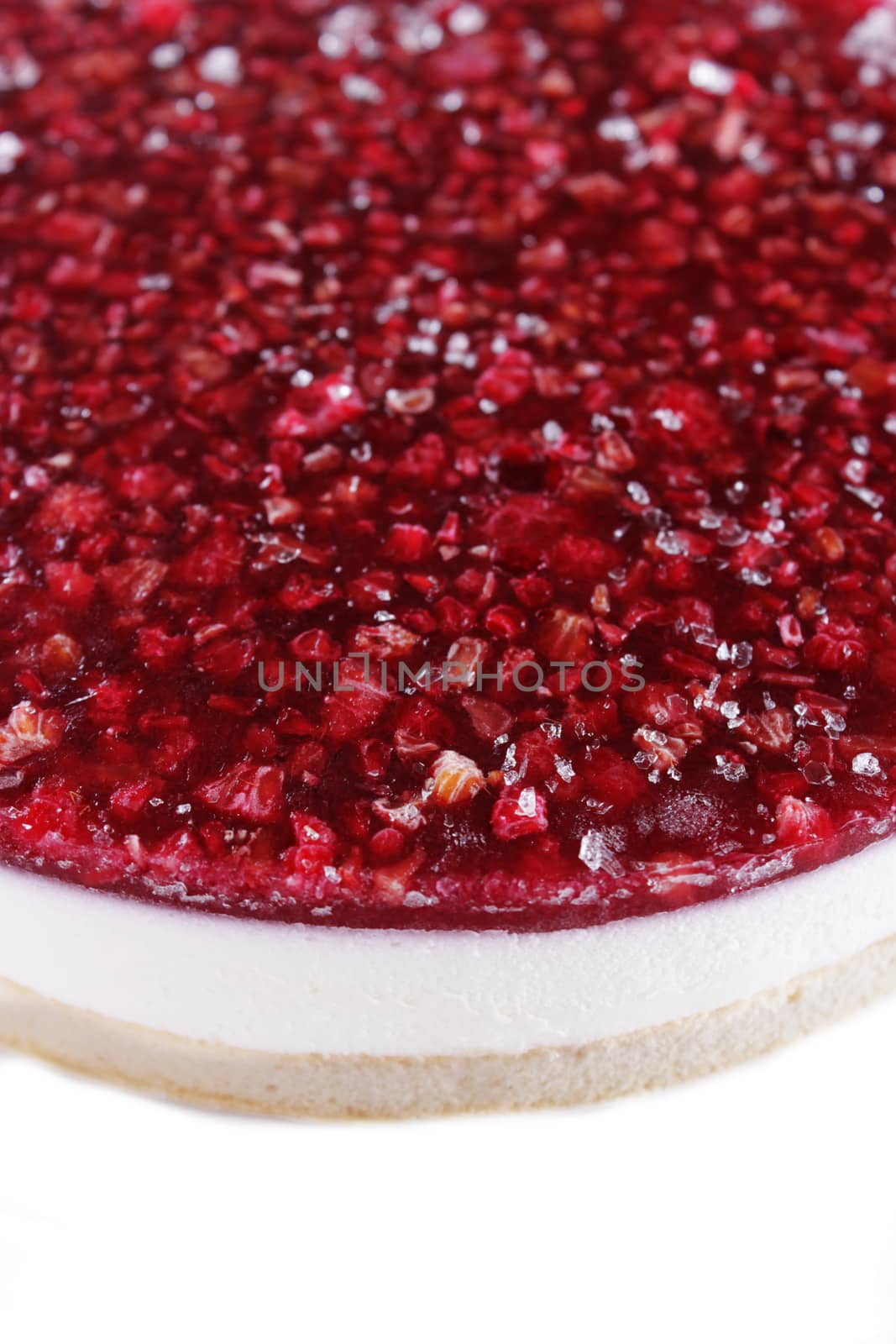 Part of cheesecake with raspberry on a plate over white