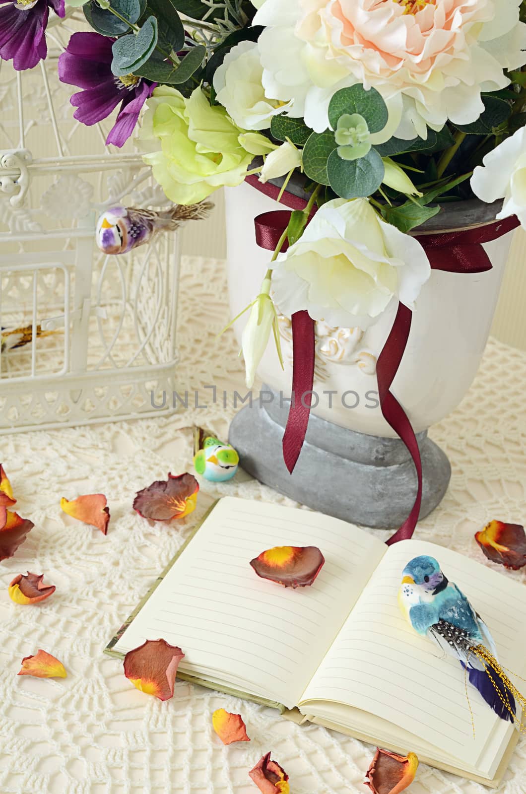 The book on a table with rose-petals