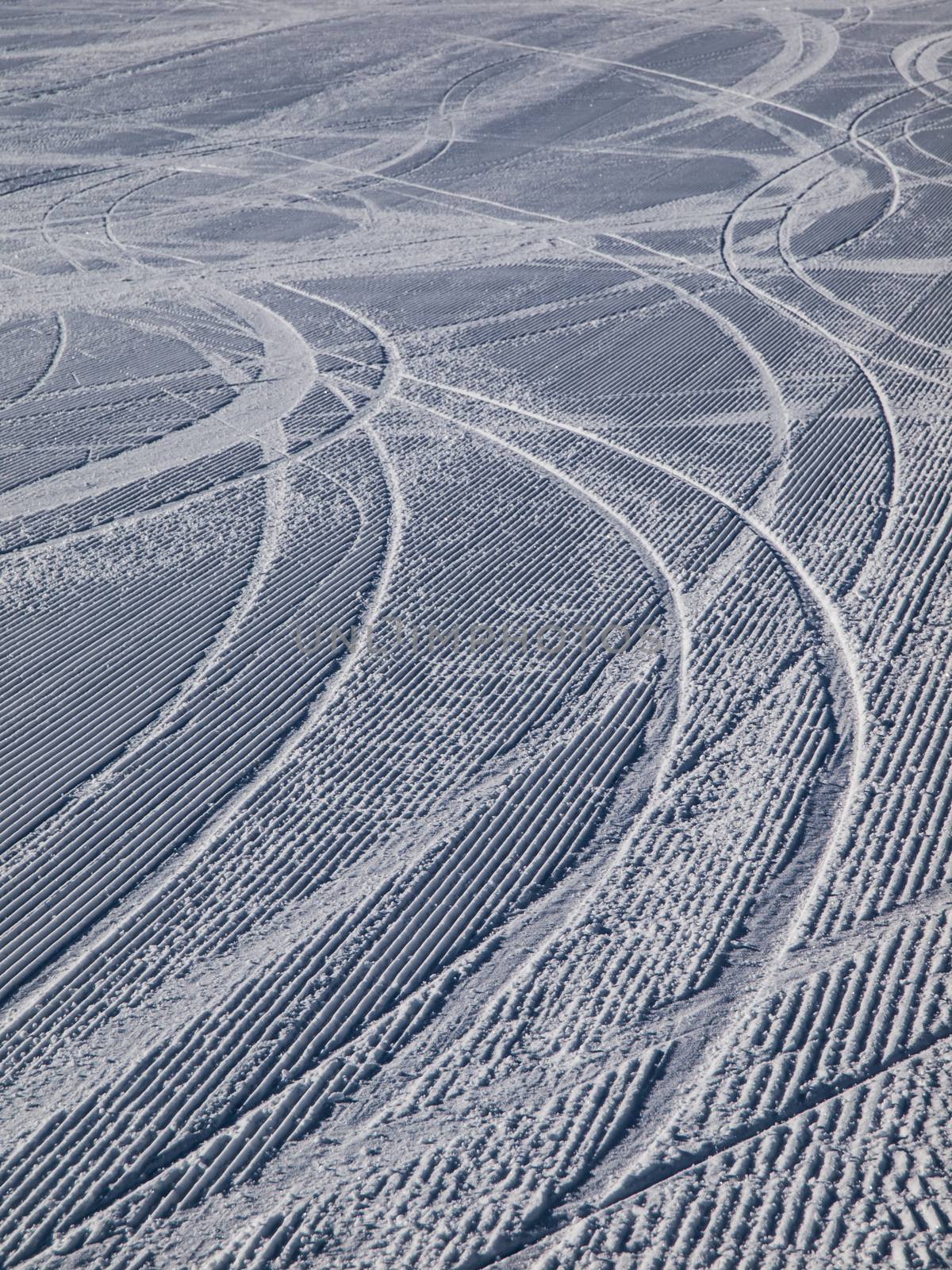 Skiing background - downhill ski tracks on ski slope
