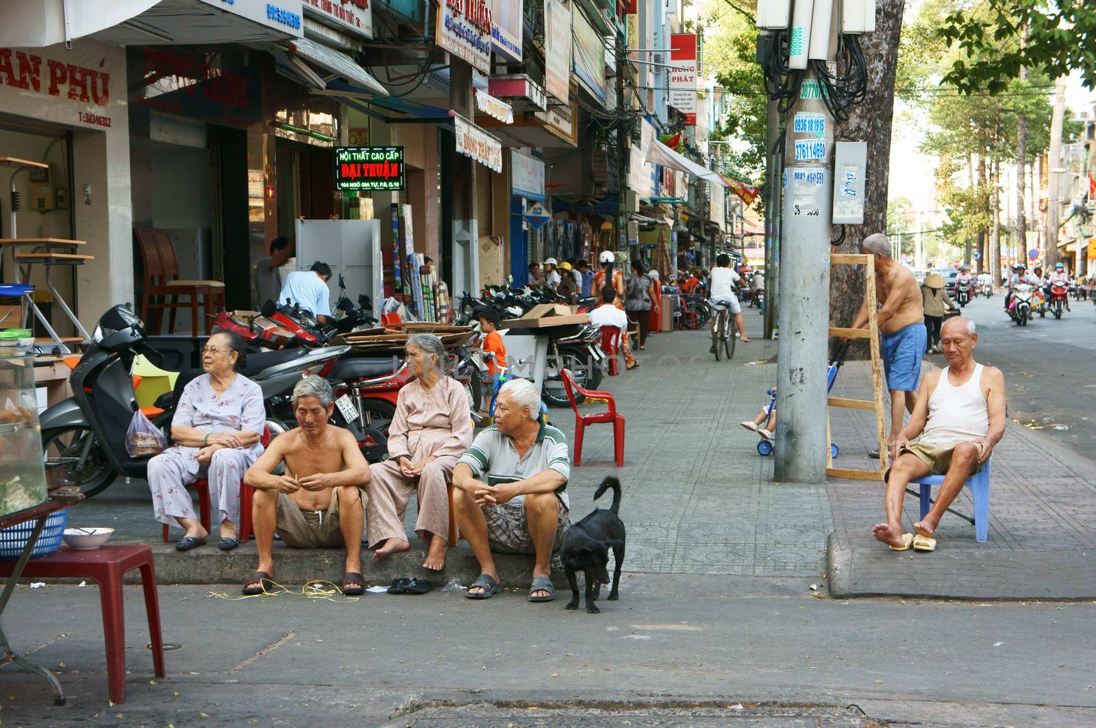 SAI GON, VIET NAM- MARCH 22: Group of elderly citizen sitting together on pavement at evening to make small talk in Sai gon, Viet Nam, March 22, 2013