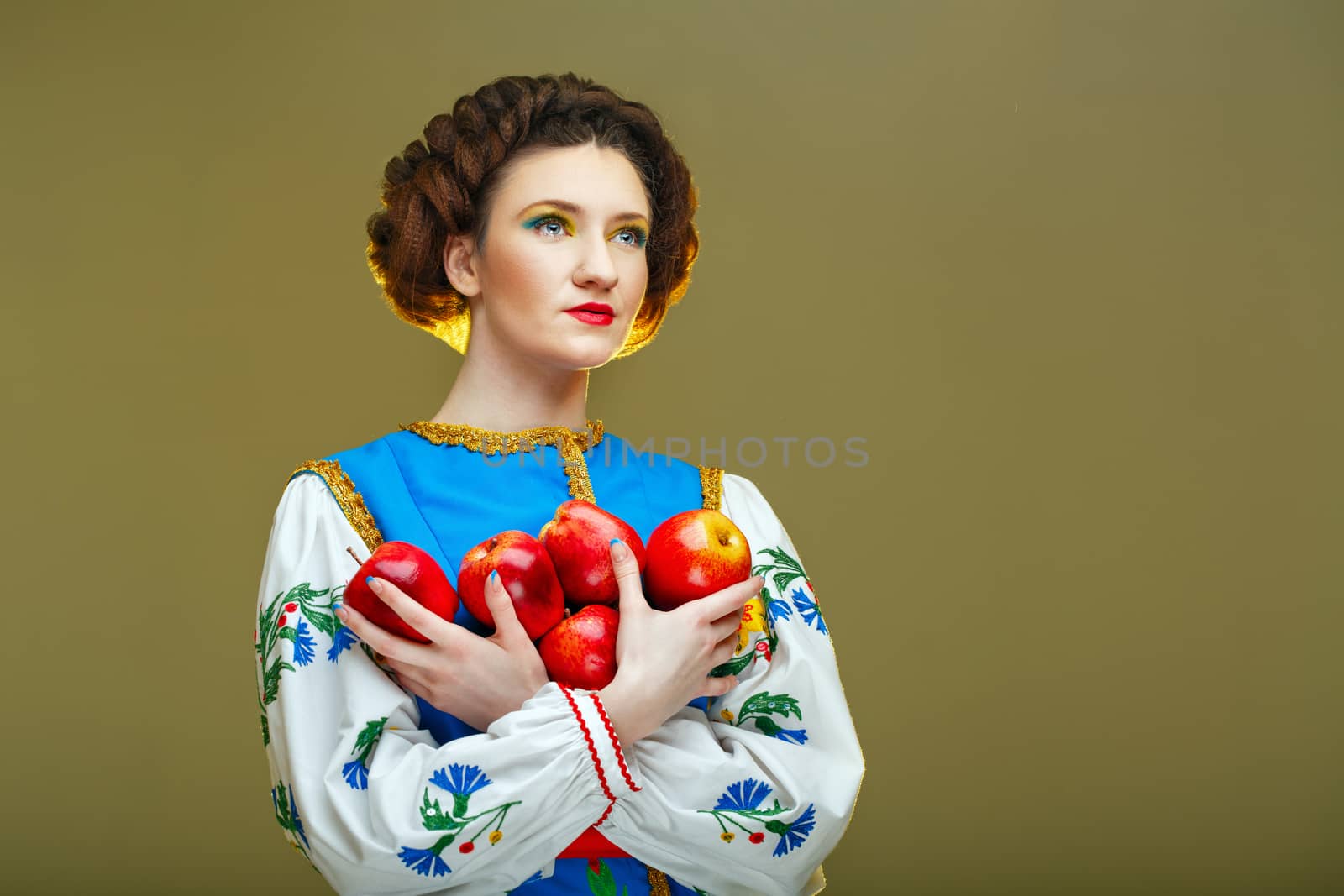 Young attractive girl in national costume eastern europe holding apples