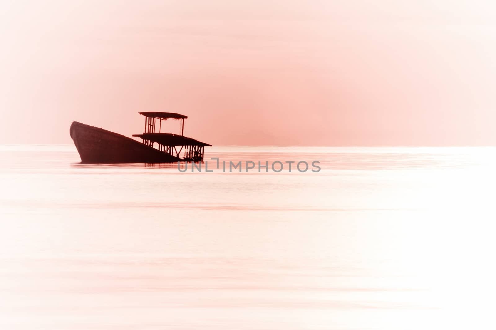 Silhouette abandon fisherman boath ove sunset sky 