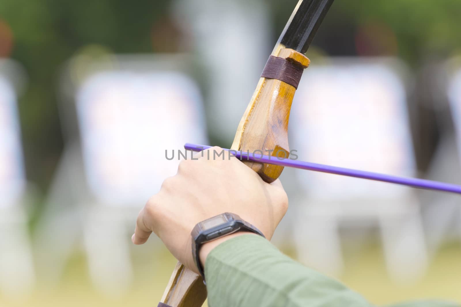 archer holds his bow aiming to the target.