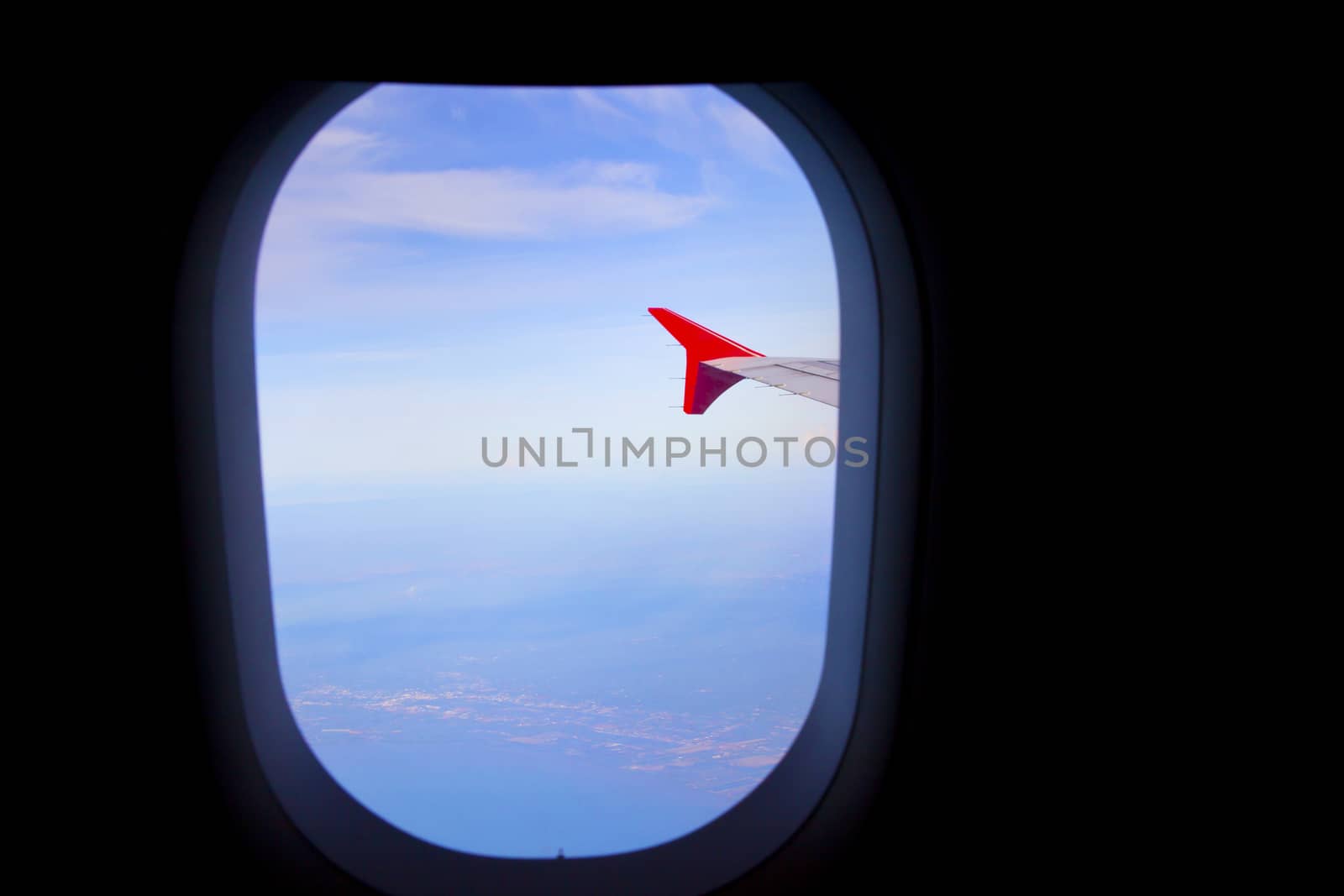 Airplane window of airplane with a beautiful sky