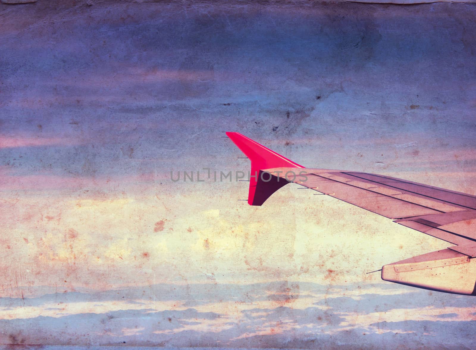Wing of the plane over blue sky background, grunge style background