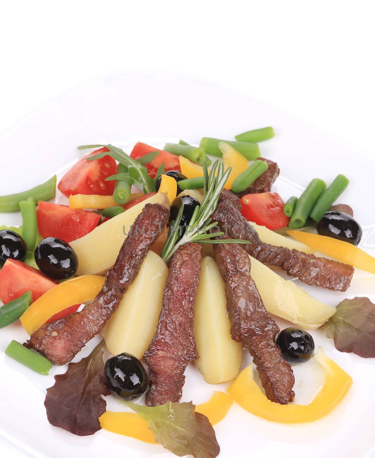 Salad with beef fillet and vegetables. Isolated on a white background.