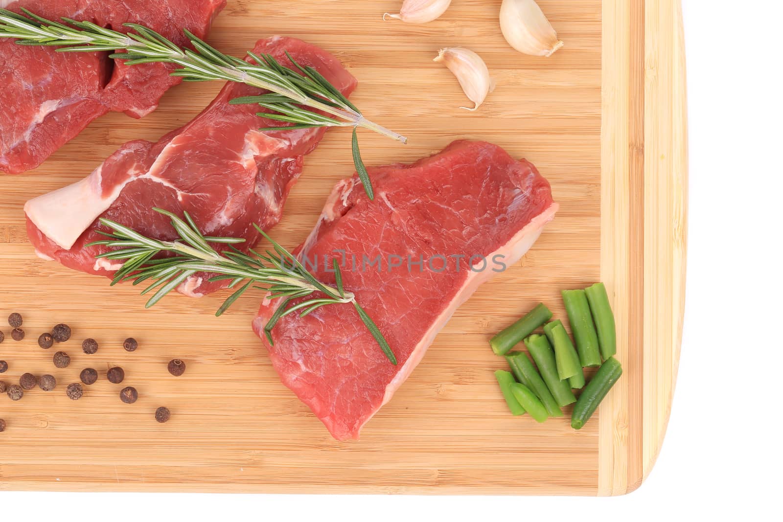 Raw steaks on cutting board. Isolated on a white background.