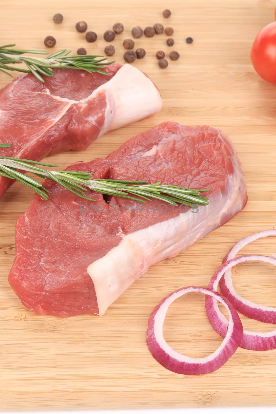 Raw steaks on cutting board.